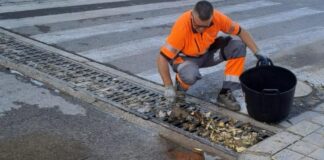 Trabajador limpiando un imbornal en Paterna para prevenir inundaciones