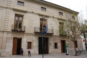 Fachada del Ayuntamiento de Catarroja con banderas y árboles.