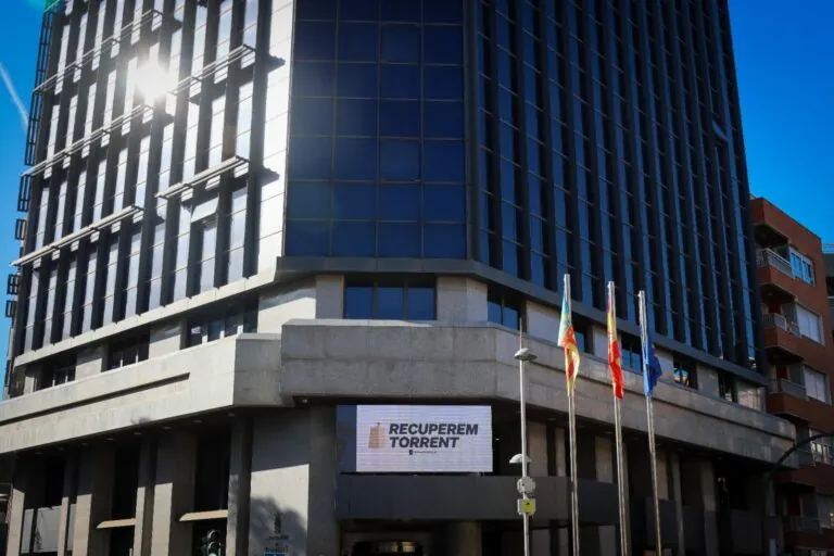 Edificio del Ayuntamiento de Torrent con banderas y cartel de Recuperem Torrent