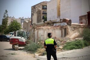 Operario y maquinaria en la demolición de casas afectadas por la DANA en Torrent