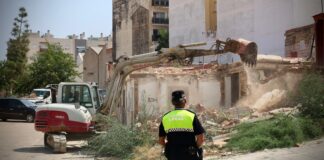 Operario y maquinaria en la demolición de casas afectadas por la DANA en Torrent