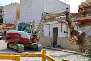 Excavadora realizando la demolición de casas afectadas en Torrent