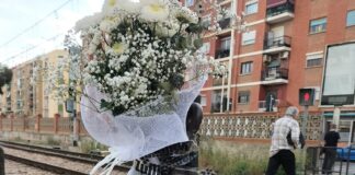Ramo de flores en un paso a nivel de tren en Alfafar