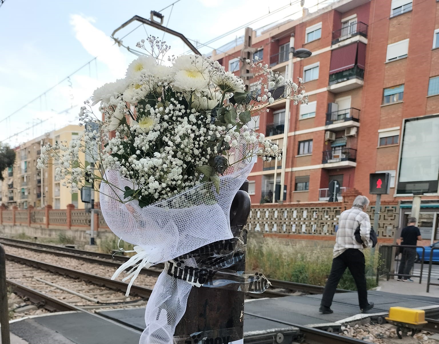Ramo de flores en un paso a nivel de tren en Alfafar