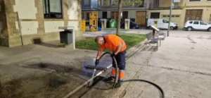 Trabajador limpiando un embornal en Massanassa con manguera
