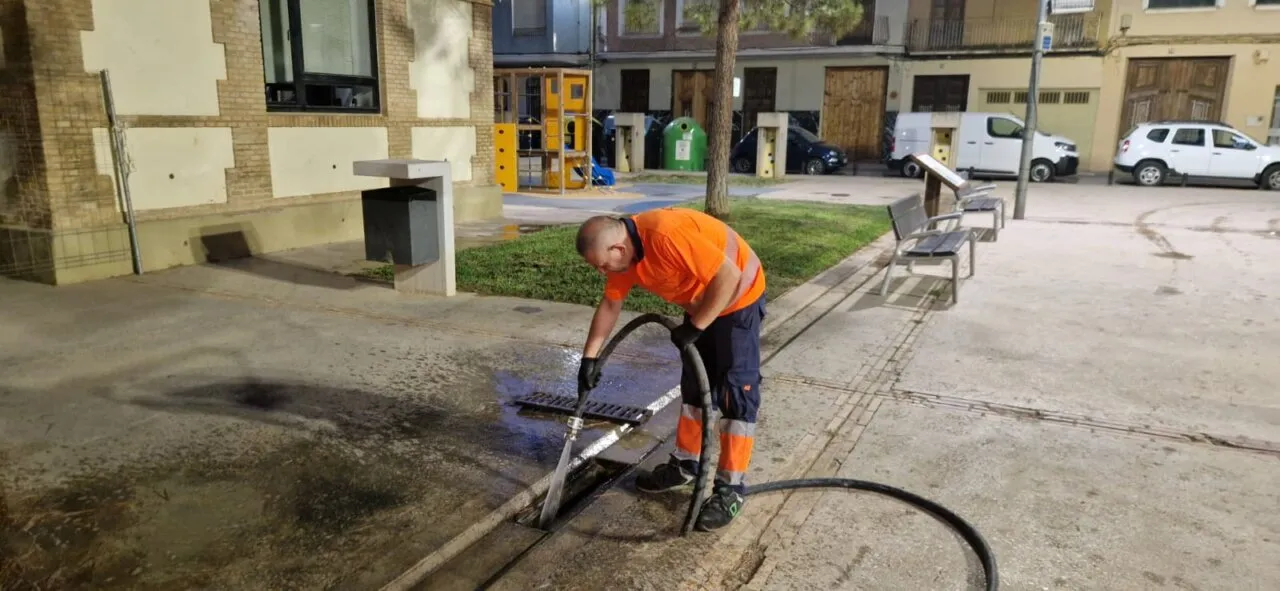 Trabajador limpiando un embornal en Massanassa con manguera