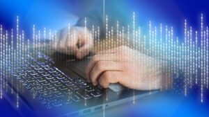 Manos escribiendo en un teclado con fondo digital de datos