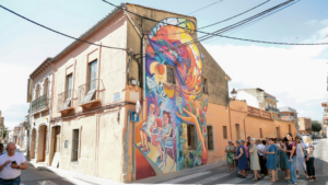 Mural urbano en Benifaraig creado por Iván Tortajada con vecinos observando