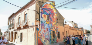 Mural urbano en Benifaraig creado por Iván Tortajada con vecinos observando