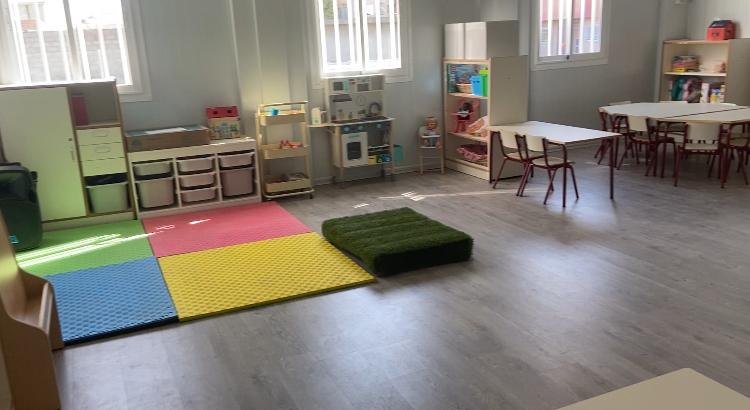 Aula de un centro escolar en Massanassa con juguetes y alfombra de colores