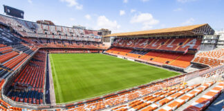 Vista del estadio Mestalla, sede del Valencia CF, con césped verde y gradas vacías.