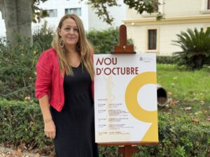 Mujer junto a cartel del evento Nou d'Octubre en Moncada