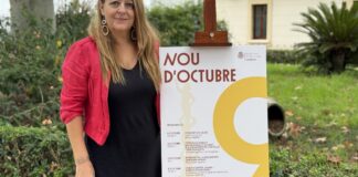 Mujer junto a cartel del evento Nou d'Octubre en Moncada