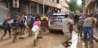 Voluntarios y policías trabajando en la limpieza tras la inundación en Paiporta
