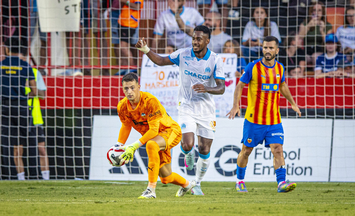 Portero del Valencia CF deteniendo un balón durante el partido contra el Olympique de Marsella