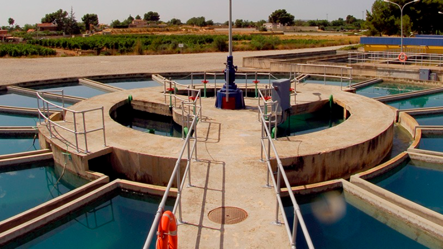 Planta de tratamiento de agua potable en Valencia con depósitos y tuberías visibles.