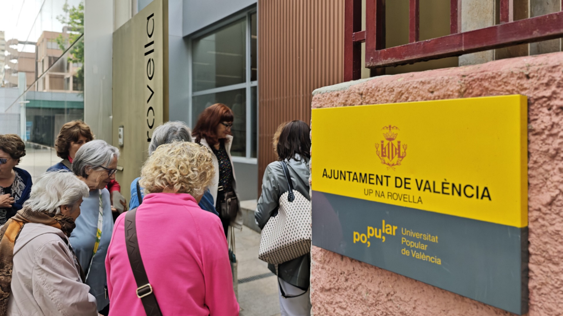 Grupo de personas en la entrada de la Universitat Popular de València