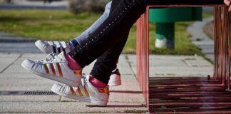 Pies de niños con zapatillas en un banco en Orriols, Valencia