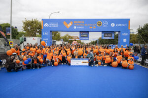 Grupo de personas con camisetas naranjas en el Medio Maratón Valencia