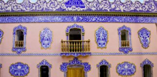 Fachada del edificio El Arte en Manises con detalles decorativos azules y rosas.