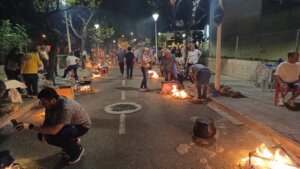 Personas cocinando allipebre en la calle durante un evento en Sedaví