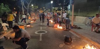 Personas cocinando allipebre en la calle durante un evento en Sedaví