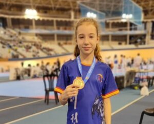Joven taekwondista sosteniendo medalla de bronce en competición