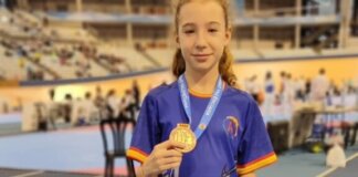 Joven taekwondista sosteniendo medalla de bronce en competición