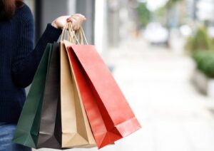 Persona sosteniendo varias bolsas de compras de diferentes colores
