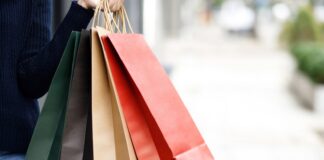 Persona sosteniendo varias bolsas de compras de diferentes colores