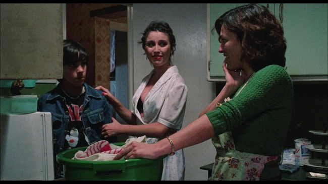 Escena de tres personas en una cocina durante un evento musical.