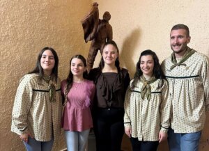 Grupo de personas junto a la escultura de Cris Calpe en homenaje a voluntarios