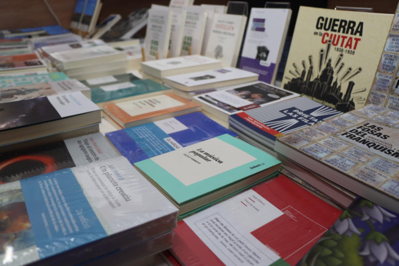 Mesa con libros variados en la Fira del Llibre de Torrent