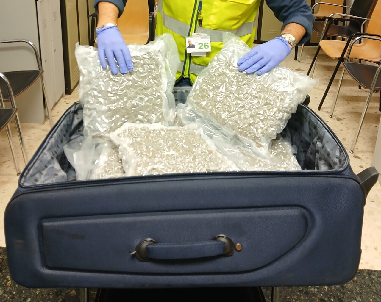 Agente de la Guardia Civil revisando maleta con marihuana