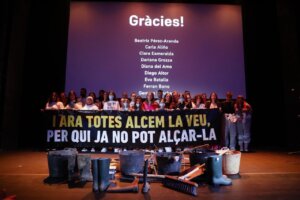 Grupo de personas en el escenario del Teatro Olympia durante un homenaje a las víctimas de la DANA.