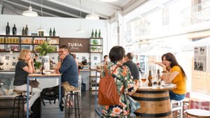 Interior del mercado de Mossén Sorell con personas degustando productos