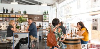 Interior del mercado de Mossén Sorell con personas degustando productos