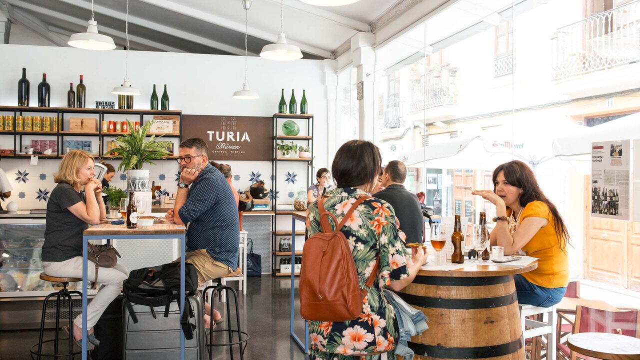 Interior del mercado de Mossén Sorell con personas degustando productos