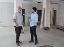 El aumento de población impulsa la apertura de un nuevo local para Servicios Sociales en Almàssera Dos hombres conversando en un local en reforma para Servicios Sociales en Almàssera