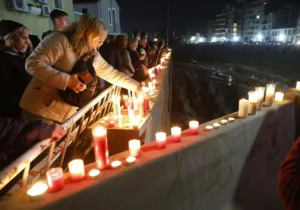 Personas encendiendo velas en homenaje a las víctimas de la DANA en Paiporta.