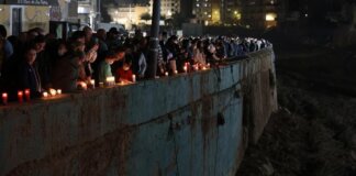 Personas encendiendo velas en un homenaje por las víctimas de la DANA en Paiporta