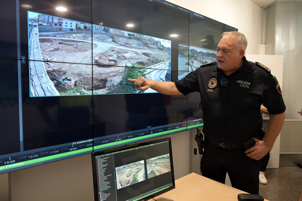 Policía local mostrando imágenes de medidores de caudal en Paiporta.