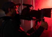 Producción audiovisual: el impulso creativo que transforma cada proyecto Hombre sosteniendo una cámara en un ambiente de producción audiovisual