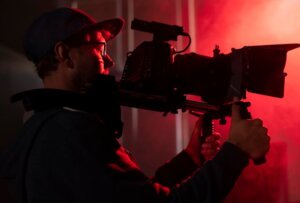 Hombre sosteniendo una cámara en un ambiente de producción audiovisual