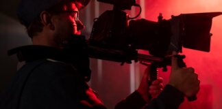Hombre sosteniendo una cámara en un ambiente de producción audiovisual