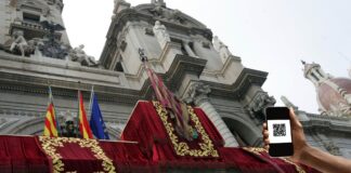 Persona sosteniendo un teléfono móvil con un código QR en València