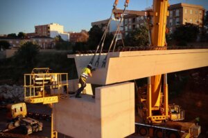 Trabajador colocando vigas en la pasarela de Mas del Jutge en Torrent