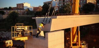 Trabajador colocando vigas en la pasarela de Mas del Jutge en Torrent