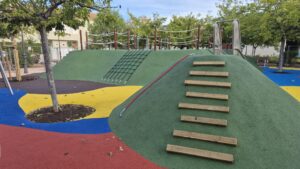 Área de juegos infantiles renovada en el Jardí Senent Ibáñez con colinas y juegos.