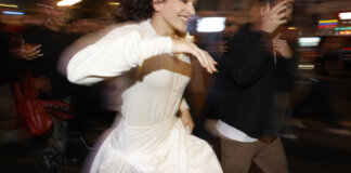 Rosalía corriendo en una calle iluminada por la noche.